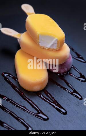 Stapel von Obst-Eis-Stick sieht frisch zu essen auf einem schwarzen Stein Hintergrund platziert. Stockfoto