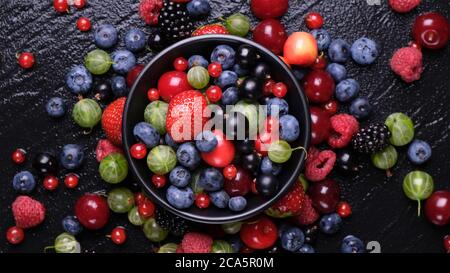 Sammlung von Waldbeeren auf schwarzem Hintergrund, Draufsicht Stockfoto