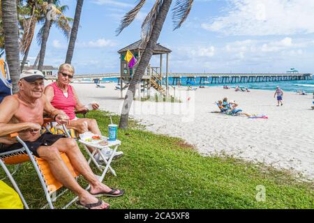 Deerfield Beach Florida, Palmen, Sand, Öffentlichkeit, Atlantikküste, Ufer, Surfen, Sonnenanbeter, Erwachsene Erwachsene Männer Männer Männer, Frau Frauen weibliche Dame, Coup Stockfoto