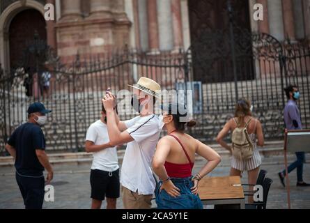 Malaga, Spanien. August 2020. Ein Tourist fotografiert auf dem Platz Plaza del Obispo, während er eine Gesichtsmaske als vorbeugende Maßnahme während der Coronavirus-Krise (COVID-19) trägt.Spanien hat bisher 297K Coronavirus-Fälle, 28,472 Todesfälle und 150K Genesung bestätigt. Kredit: SOPA Images Limited/Alamy Live Nachrichten Stockfoto