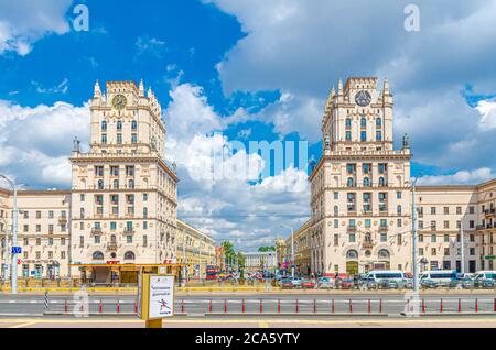 Minsk, Belarus, 26. Juli 2020: Die Tore von Minsk zwei hohe Türme Sozialistischen Klassizismus Stalin Empire-Stil Gebäude mit Uhr auf Bahnhof Platz, blauer Himmel weißen Wolken in sonnigen Sommertag Stockfoto