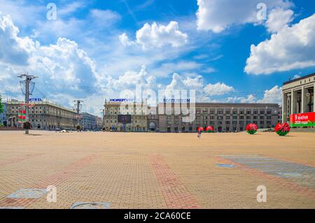 Minsk, Weißrussland, 26. Juli 2020: Oktoberplatz mit sozialistischem Klassizismus Gebäude im Stil des Stalinreiches, blauer Himmel weiße Wolken am sonnigen Sommertag Stockfoto