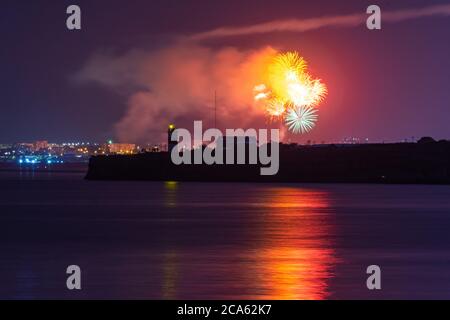 Feierlicher Gruß über der Stadt Sewastopol am Tag der Marine. Helle bunte Lichtimpulse des Feuerwerks. Das Konzept der Feier. Nacht sho Stockfoto