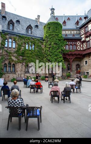 Wernigerode, Deutschland. August 2020. Barbara Toppel (l-r), Jaehyun Han und Alexey Naumenko vom Philharmonischen Kammerorchester Wernigerode spielen im Hof des Schlosses Wernigerode für Teilnehmer einer Soiree. Aufgrund der Ausbreitung des Coronavirus musste das jährliche Burgfest in seiner ursprünglich angekündigten Form abgesagt werden. Jetzt gibt es noch bis zum 29. August 2020 Soirees im Schlosshof und samstags Konzerte im Marstall.Quelle: Klaus-Dietmar Gabbert/dpa-Zentralbild/dpa/Alamy Live News Stockfoto
