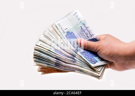 Lady hält pakistanische Währung Banknoten isoliert auf weißem Hintergrund Stockfoto