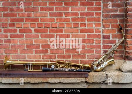 Musikinstrumente einschließlich Posaune Trompete Klarinette und Saxophon an Backsteinwand vor Jazz Club Stockfoto