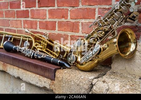 Musikinstrumente einschließlich Posaune Trompete Klarinette und Saxophon an Backsteinwand vor Jazz Club Stockfoto