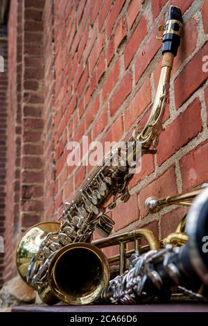 Musikinstrumente einschließlich Posaune Trompete Klarinette und Saxophon an Backsteinwand vor Jazz Club Stockfoto