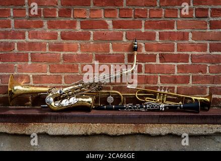 Musikinstrumente einschließlich Posaune Trompete Klarinette und Saxophon an Backsteinwand vor Jazz Club Stockfoto