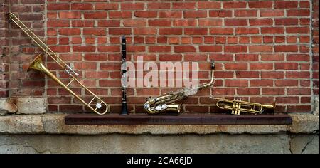 Musikinstrumente einschließlich Posaune Trompete Klarinette und Saxophon an Backsteinwand vor Jazz Club Stockfoto