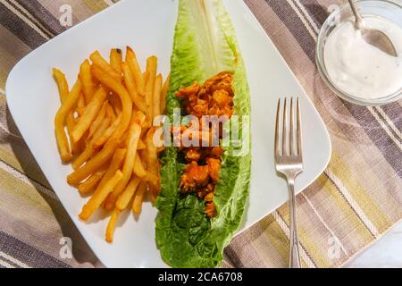 Glutenfreie Büffelbüffel-Hähnchensalat-Sandwich-Wrap mit knusprigen pommes frites Stockfoto