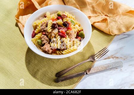 Italienische Wurst Rotini Pasta mit castelvetrano und kalamata Oliven und Kidney Bohnen in einer leichten Tomaten Weißwein Butter Sauce Stockfoto