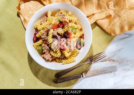 Italienische Wurst Rotini Pasta mit castelvetrano und kalamata Oliven und Kidney Bohnen in einer leichten Tomaten Weißwein Butter Sauce Stockfoto