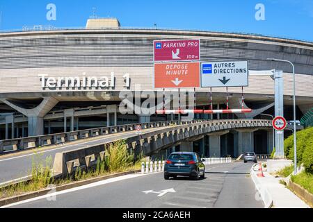 An sonnigen Tagen erreichen Pkw das kreisförmige Gebäude des Terminals 1 des Flughafens Paris-Charles de Gaulle über die Zufahrtsstraße. Stockfoto