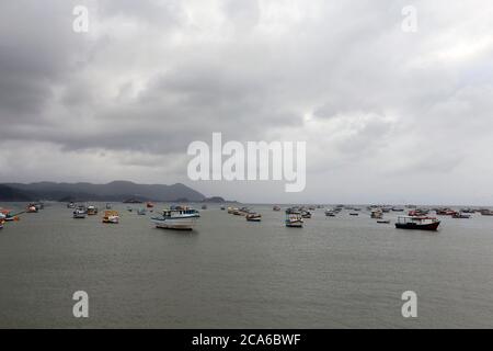 Fischerboot auf dem Meer in bewölktem Tag auf Guaruja, Sao Paulo, Brasilien Stockfoto