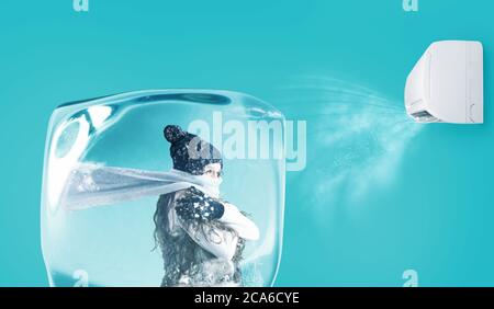 Frau gefroren in einem Eiswürfel unter dem Luftstrahl einer Klimaanlage auf cyanfarbenem Hintergrund Stockfoto