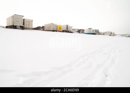 Wechselnde Hütten im Schnee am Belriot Plage Strand während eines bewölkten Tages Stockfoto