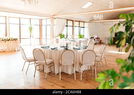 Runder rosafarbener Tisch mit der Nummer drei und Aufstellungs- und Stühlen um ihn herum im Restaurant Stockfoto