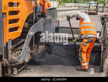Straßenarbeiten, Anwendung von neuem Asphalt auf der deutschen Autobahn Stockfoto