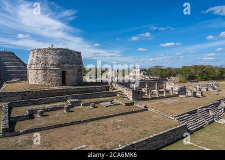 Der Rundtempel oder Observatorium in den Ruinen der post-klassischen Maya-Stadt Mayapan, Yucatan, Mexiko. Links ist die Pyramide von Kukulkan mit einer st Stockfoto