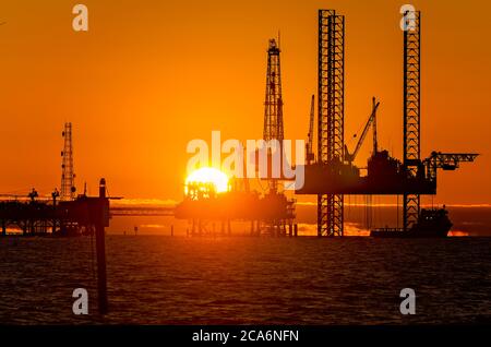 Die Sonne geht hinter einer Erdgasanlage auf, 20. April 2014, auf Dauphin Island, Alabama. Stockfoto