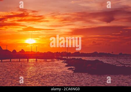 Die Sonne untergeht über dem Wasser, 22. Juli 2020, in Dauphin Island, Alabama. Stockfoto