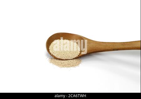 Instant Hefe isoliert auf weiß. Trockene Hefe in Holzlöffel auf weißem Hintergrund Stockfoto