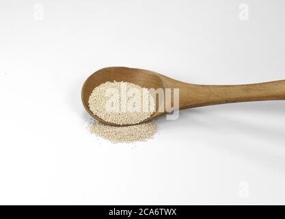Instant Hefe isoliert auf weiß. Trockene Hefe in Holzlöffel auf weißem Hintergrund Stockfoto
