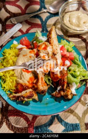 Naher Osten Huhn Shawarma Salat Reisplatte mit Hummus und Frühlingsgemüse Stockfoto