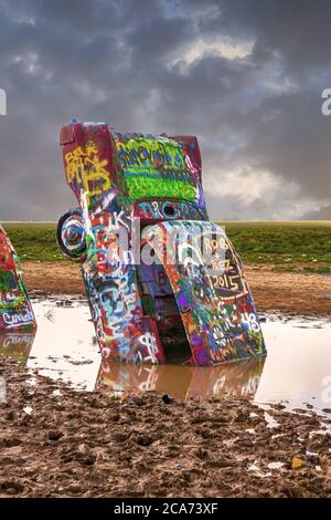 Cadillac Ranch mit seinen hoch lackierten Fahrzeugen in der Mitte eines schlammigen Feld etwas außerhalb Amarillo, Texas Stockfoto