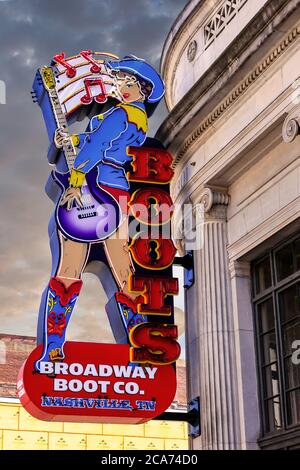 Das Schild der Brigt Overhead Neon Light Cowgirl vor dem Broadway Boot Company Store in der Innenstadt von Nashville, TN Stockfoto