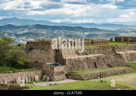 Der Blick auf das Gebäude L und den Patio de los Danzantes auf die präkolumbianischen Zapoteken-Ruinen von Monte Alban in Oaxaca, Mexiko. Ein UNESCO-Welterbe Stockfoto