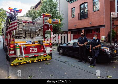 Zwei NYPD-Offiziere des 78th Precinct auf der Szene von abgestürzten Bäumen auf der 7th Street in der Park Slope Nachbarschaft von Brooklyn, als FDNY Feuerwehrleute von Engine 239/Ladder 122 die Szene räumen. (Foto von Gabriele Holtermann/Sipa USA) Quelle: SIPA USA/Alamy Live News Stockfoto