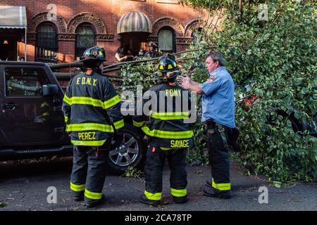 FDNY Firefighters of Engine 239/Ladder 122 räumen umgestürzte Bäume in der 7th Street im Park Slope-Viertel von Brooklyn, nachdem der tropische Sturm Isaias New York City am 4. August 2020 getroffen hatte. (Foto von Gabriele Holtermann/Sipa USA) Quelle: SIPA USA/Alamy Live News Stockfoto