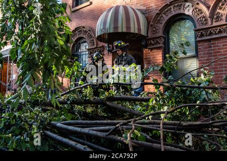 FDNY Firefighters of Engine 239/Ladder 122 räumen einen gefallenen Baum vor einem Haus in der 7th Street im Park Slope-Viertel von Brooklyn, nachdem der tropische Sturm Isaias New York City am 4. August 2020 getroffen hat. (Foto von Gabriele Holtermann/Sipa USA) Quelle: SIPA USA/Alamy Live News Stockfoto