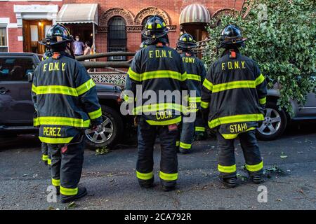 FDNY Firefighters of Engine 239/Ladder 122 räumen einen gefallenen Baum vor einem Haus in der 7th Street im Park Slope-Viertel von Brooklyn, nachdem der tropische Sturm Isaias New York City am 4. August 2020 getroffen hat. (Foto von Gabriele Holtermann/Sipa USA) Quelle: SIPA USA/Alamy Live News Stockfoto