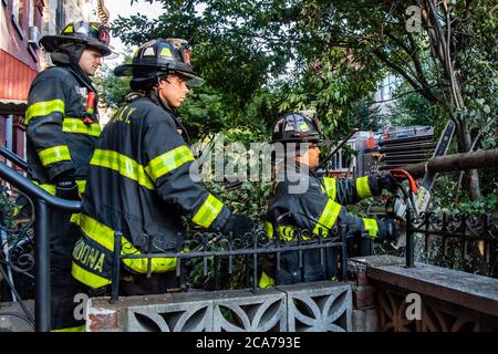 FDNY Firefighters of Engine 239/Ladder 122 räumen einen gefallenen Baum vor einem Haus in der 7th Street im Park Slope-Viertel von Brooklyn, nachdem der tropische Sturm Isaias New York City am 4. August 2020 getroffen hat. (Foto von Gabriele Holtermann/Sipa USA) Quelle: SIPA USA/Alamy Live News Stockfoto