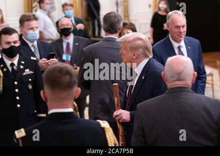 US-Präsident Donald J. Trump geht mit einem Spazierstock, der ihm von US-Senator Lamar Alexander (Republikaner von Tennessee) während einer Unterzeichnungszeremonie für H.R. 1957 - The Great American Outdoors Act im East Room des Weißen Hauses in Washington, DC, am Dienstag gegeben wurde, 4. August 2020.Quelle: Chris Kleponis/Pool via CNP - weltweite Nutzung Stockfoto