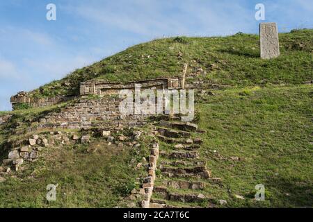 Die teilweise restaurierte Südseite von Gebäude E und Stela VGE-2 in den präkolumbianischen Zapoteken-Ruinen von Monte Alban in Oaxaca, Mexiko. EIN UNESCO WELT H Stockfoto