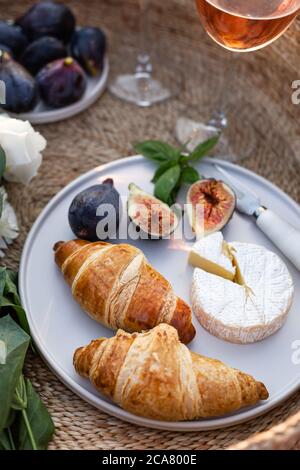 Vertikales Bild von Croissants, Feigen und Kamberkäse in einem minimalistischen weißen Teller. Stockfoto