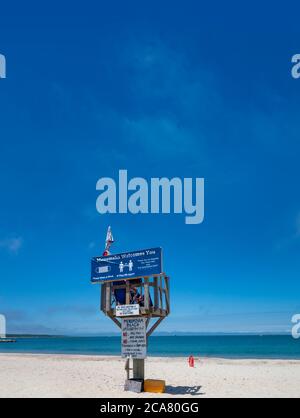 Willkommen bei menemsha Strand Schild mit sozialen Distanzierung und Maske requirments und Strand Regeln an einem Sommertag Stockfoto