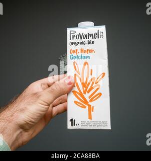 Paris, Frankreich - 29. Mai 2020: Mann Hand hält vor grauem Hintergrund Verpackung mit Provamel Bio hafer Bio-hafer Calcium tetra Packung Stockfoto