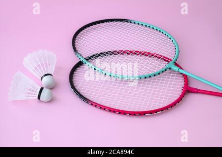 Zwei Badminton Schläger und Federball auf rosa Hintergrund. Flach liegend, Freizeitausrüstung. Sportspiel-Konzept Stockfoto