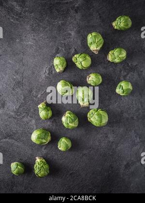 Frische grüne rosenkohl (Brassica Oleracea) verschüttet auf dunklem Hintergrund. Overhead-Aufnahme mit Kopierplatz. Stockfoto