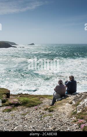 Touristen genießen die Aussicht von Pentire Point East an der Küste von Newquay in Cornwall. Stockfoto