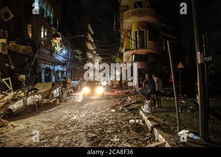 Beirut, Libanon. 4. August 2020. Männer sitzen und beobachten die Verwüstung auf der Armenia Street im Gemmayzeh-Viertel nach einer gewaltigen Explosion im Hafen der Hauptstadt. Die Sprengwelle der Detonation verursachte Schäden an bis zu sechs Meilen entfernten Gebäuden, tötete über 200 Menschen und verletzte mehr als 6000 Menschen. Kredit: Elizabeth Fitt/Alamy Live Nachrichten Stockfoto