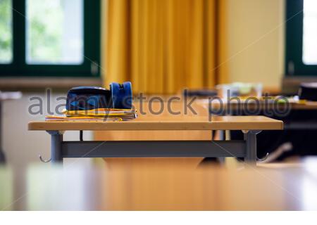 Eine Kopie- und Bleistifttasche eines Schülers auf einem Schreibtisch in einem deutschen Mittelschulraum während der Corona-Krise. Covid 19 hat Schulen dazu gebracht, sich anzupassen. Stockfoto