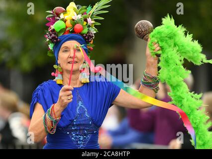 Benalla Festival 2019. Eine hell gekleidete Frau mit Früchten auf dem Kopf. Stockfoto