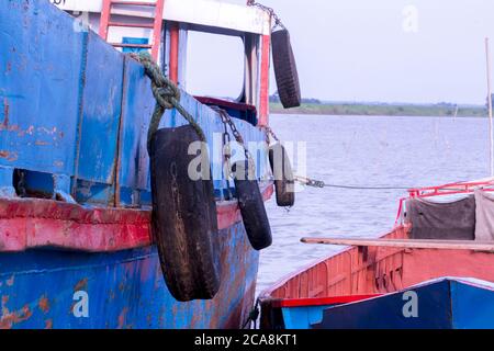 Alte Autoreifen hängen es, um die Auswirkungen des Schiffes zu reduzieren Stockfoto