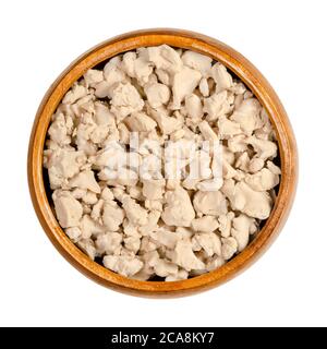 Zerbröckelte frische Backhefe in einer Holzschüssel. Komprimierte frische Hefe, mit Fingern zerkleinert, zum Backen als Laugenmittel verwendet. Saccharomyces cerevis Stockfoto